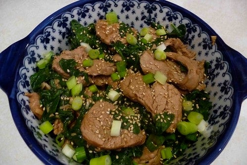 Four-Spice Pork with Spinach in a blue and white bowl.