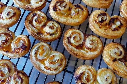 Chutney and cheese palmiers on a baking rack.