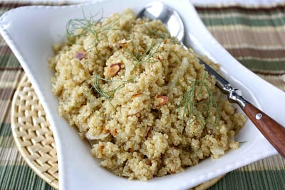 Braised fennel, quinoa and almonds in a white serving dish.