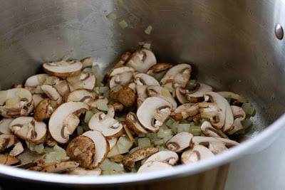 Sliced mushrooms in a large saucepan.