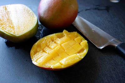 Cutting a mango into cubes.