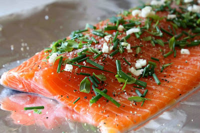 Raw salmon topped with fresh herbs and raw garlic.