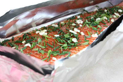Herb-topped salmon on a sheet of foil.
