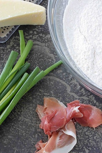 Prosciutto, green onions, Parmesan and bowl of flour.