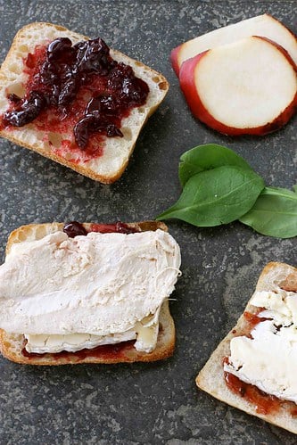 Open sandwiches topped with cherry jam and turkey.