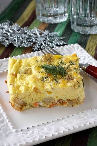 Egg casserole with potatoes and salmon on a white plate.