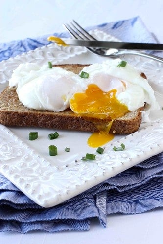 Poached egg on toast on a white plate.