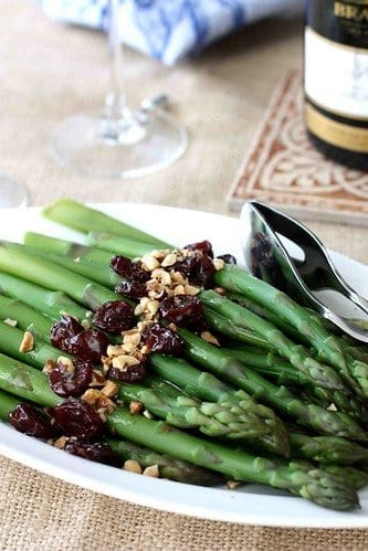 Cooked asparagus topped with hazelnuts and dried cherries.