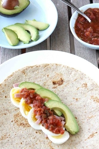 A breakfast wrap topped with salsa.