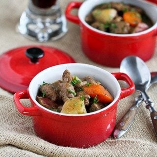 Lamb and potato stew in a small red crock.