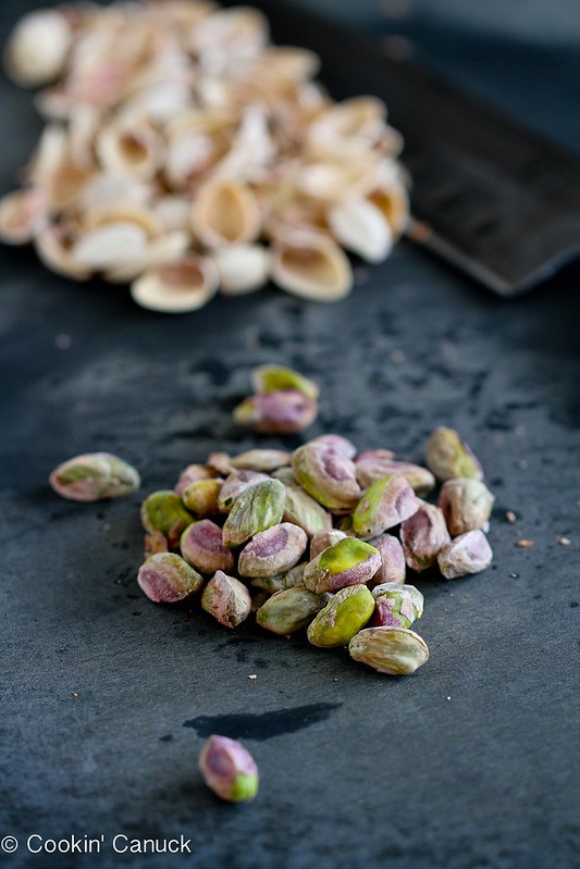 Pistachios and shells on a cutting board.