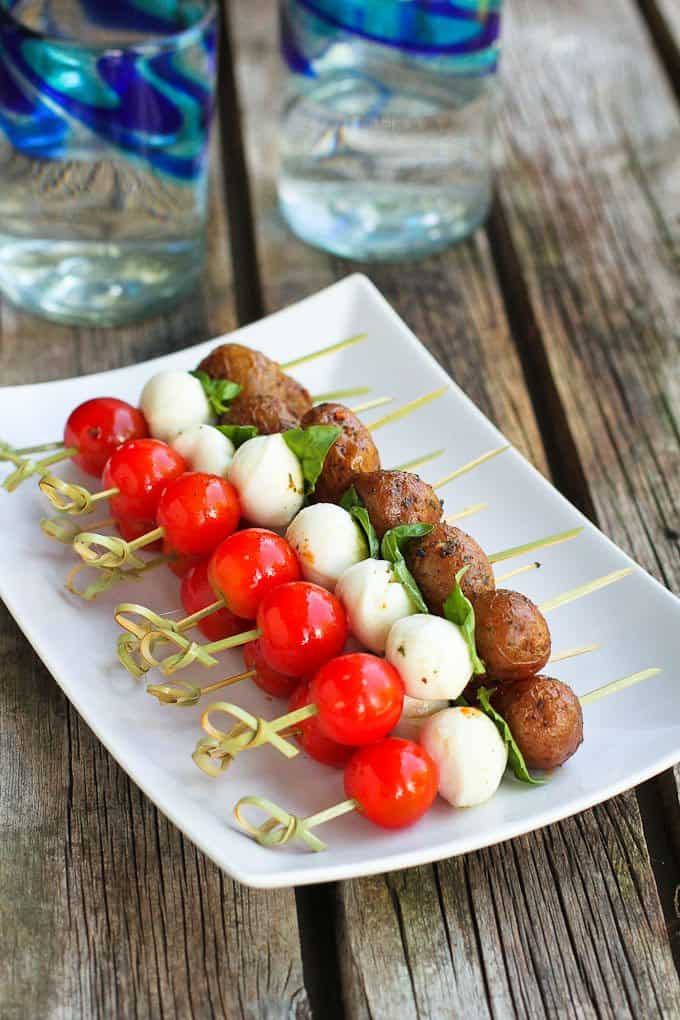 These caprese appetizer skewers are made a thousand times better with the addition of tender Creamer potatoes. Our new favorite summertime appetizer! 85 calories and 2 Weight Watchers Freestyle SP #appetizer #caprese