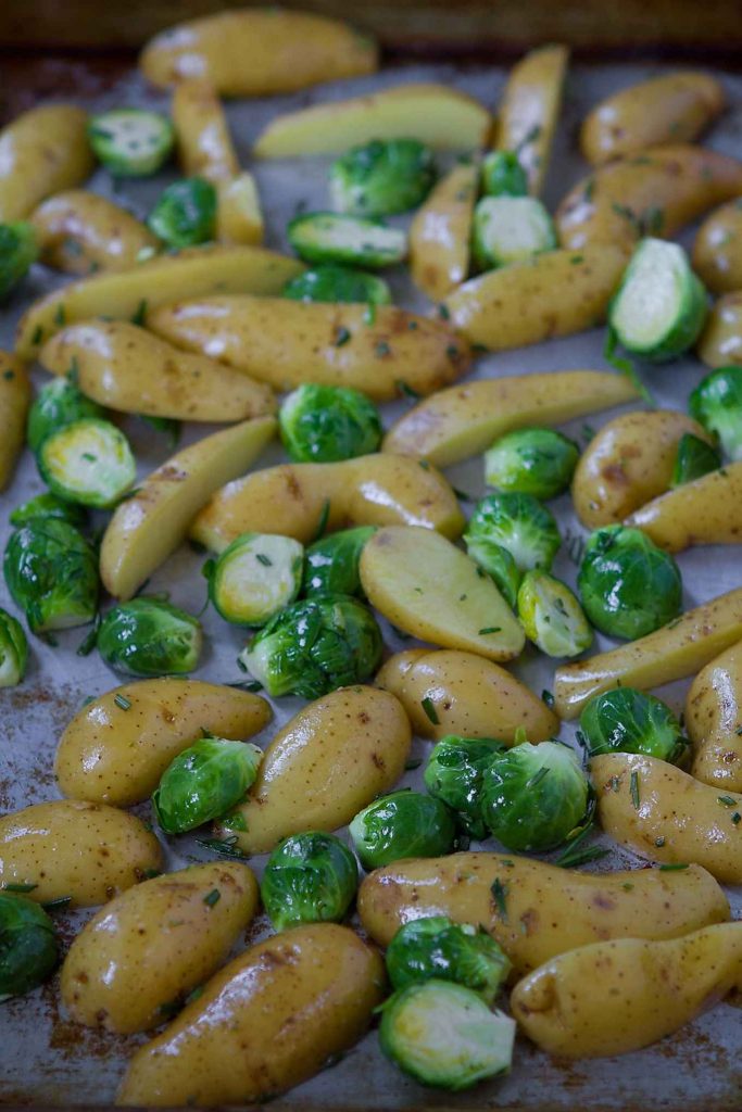 Fingerling potatoes and Brussels sprouts on sheet pan, ready to roast.