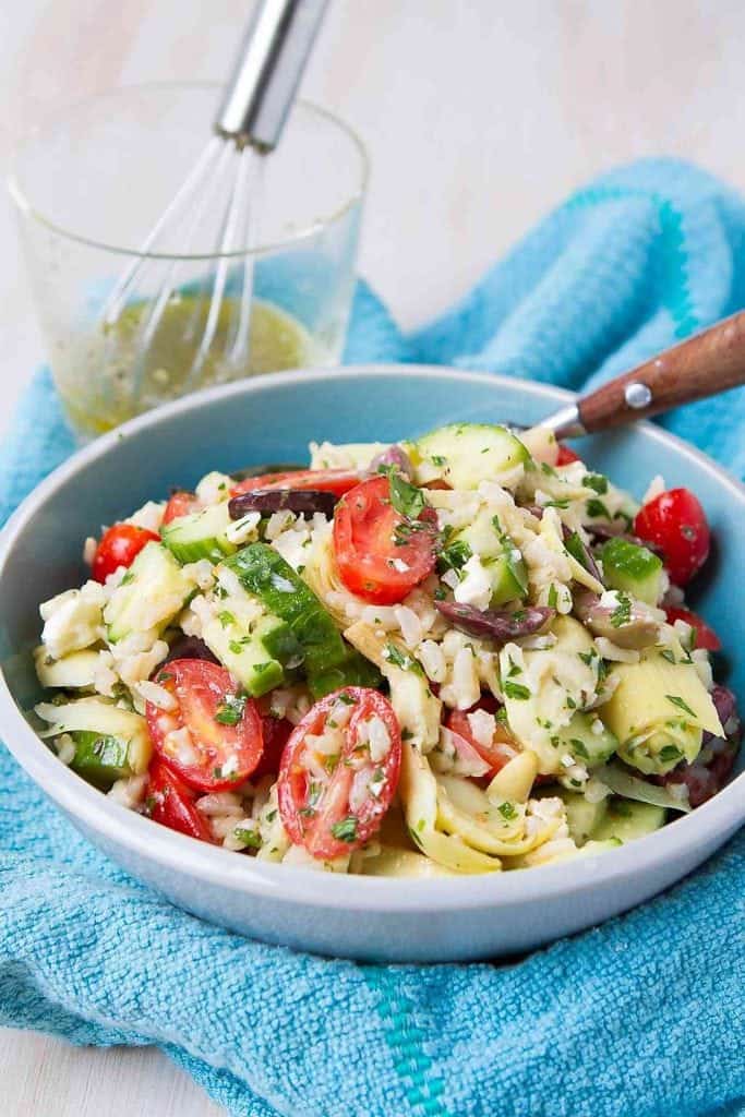 The perfect potluck salad! This easy rice salad recipe has all of the flavors of your favorite Greek salad. 125 calories and 4 Weight Watchers Freestyle SP #salad #rice #healthy #cleaneating