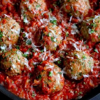 Large turkey meatballs in a skillet with homemade tomato sauce.