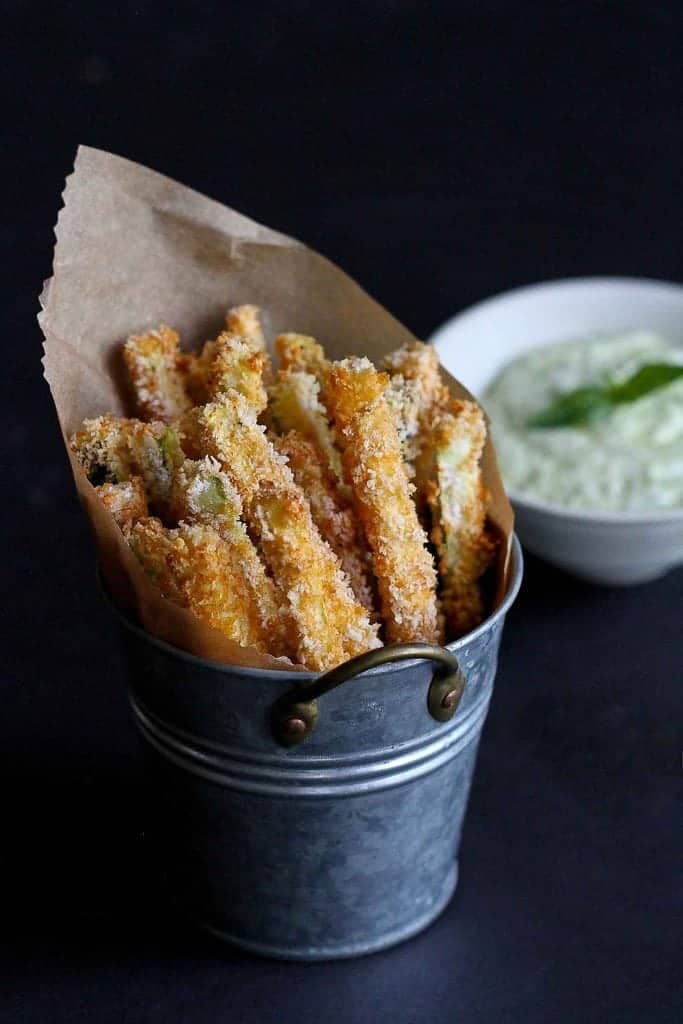 You're going to love these! Zucchini gets transformed into healthy, crispy, golden brown baked zucchini fries with a 3-ingredient pesto yogurt dipping sauce. 113 calories and 3 Weight Watchers SP | Vegetarian | Snacks healthy | Easy | Panko | Baked Parmesan | Oven #zucchinifries #bakedzucchinifries #healthyappetizers #healthysnacks #yogurtdip