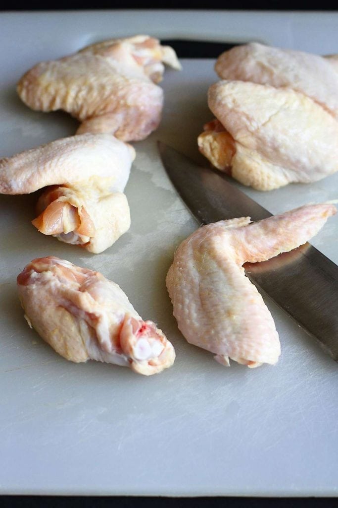 Separating chicken wings by cutting the joint between the wing and the drumette.