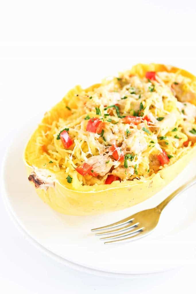 Chicken stuffed spaghetti squash is taken to a whole new level in this easy recipe. It is stuffed with veggies and flavored with pesto for a healthy dinner. 230 calories and 5 Weight Watchers SP | Healthy | Easy | Recipes | SmartPoints | Clean Eating | Italian | Mediterranean #spaghettisquash #chickenrecipes #squashrecipes #cleaneating #healthydinners #weightwatchers