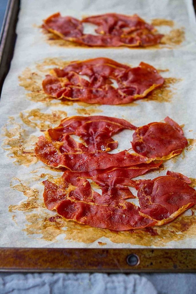 Baked prosciutto on a baking sheet.