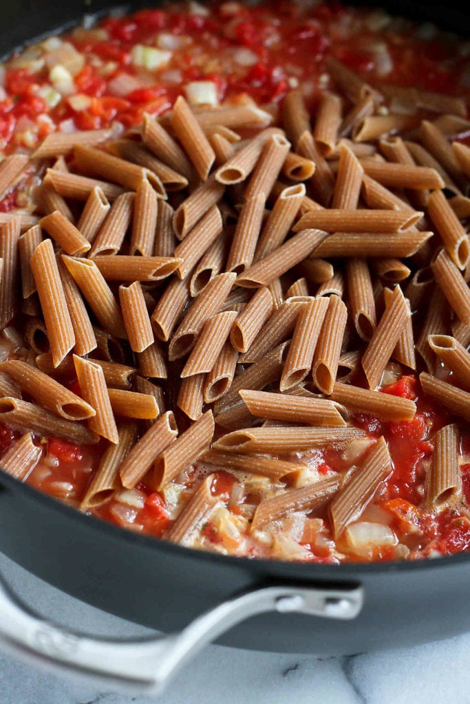 Whole wheat pasta added to a tomato sauce.