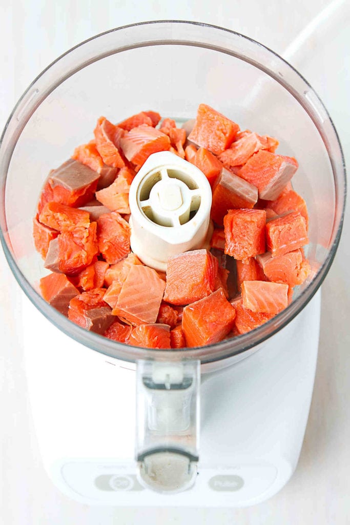 Salmon pieces in food processor, ready to chop.