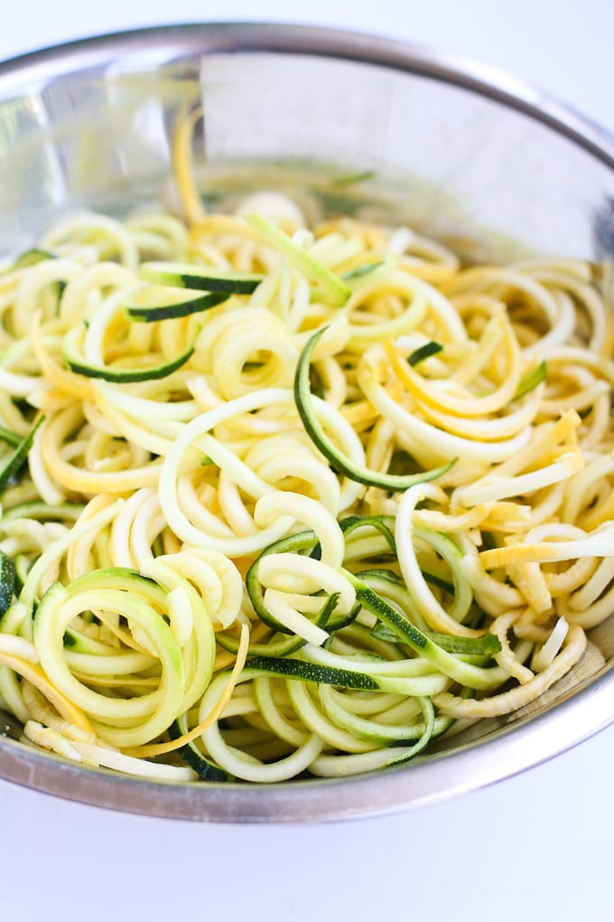 Spiralized yellow squash and zucchini noodles in a bowl.