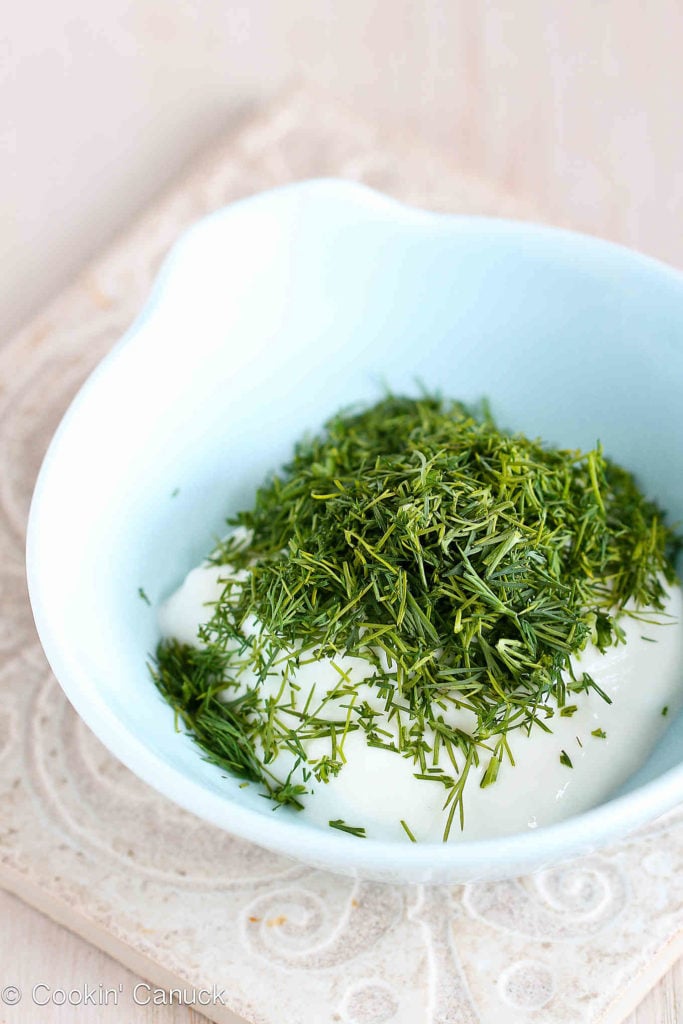 Yogurt and chopped dill in a small, blue bowl.