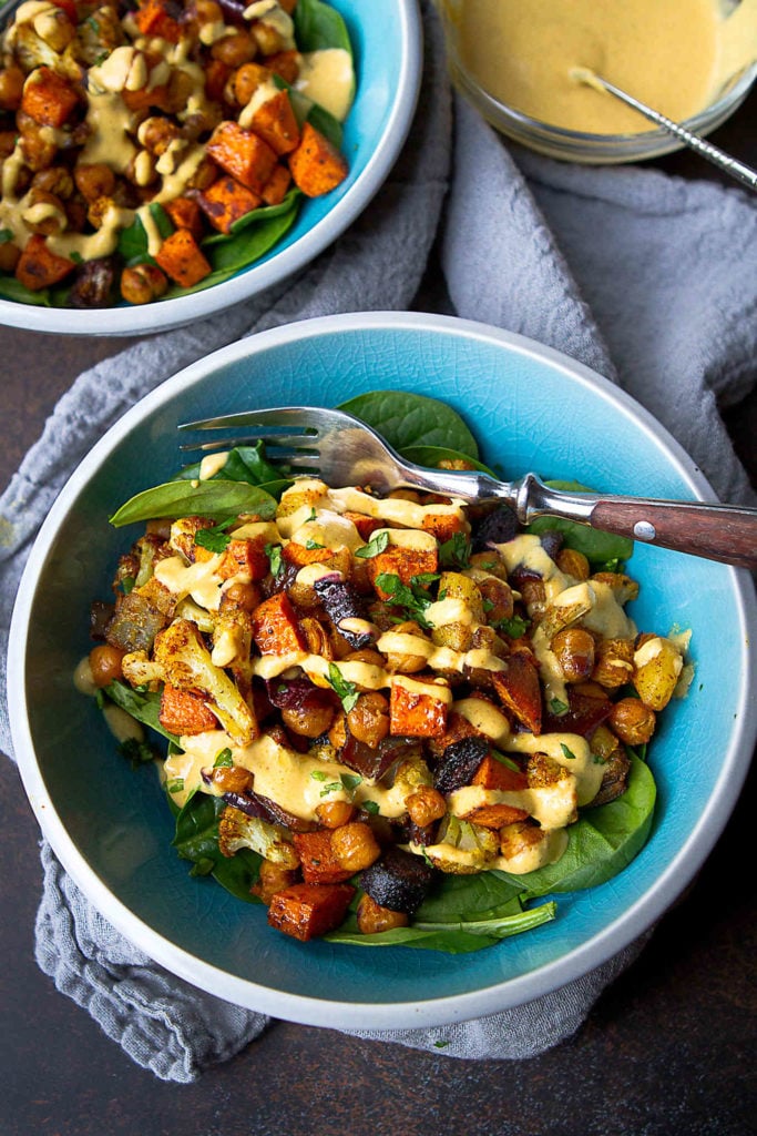 Oven roasted vegetables are a great way to add flavor to these vegan chickpea bowls. Drizzled with an easy hummus dressing. 284 calories and 6 Weight Watchers Freestyle SP #vegetarian #cleaneating