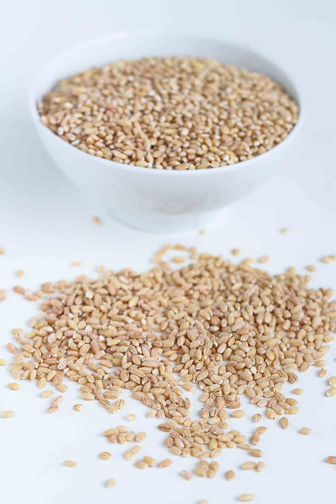 A bowl of barley on a white table.