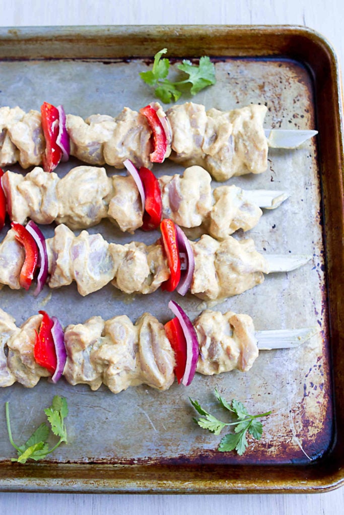 Yogurt marinated chicken, red bell peppers and onion on skewers.