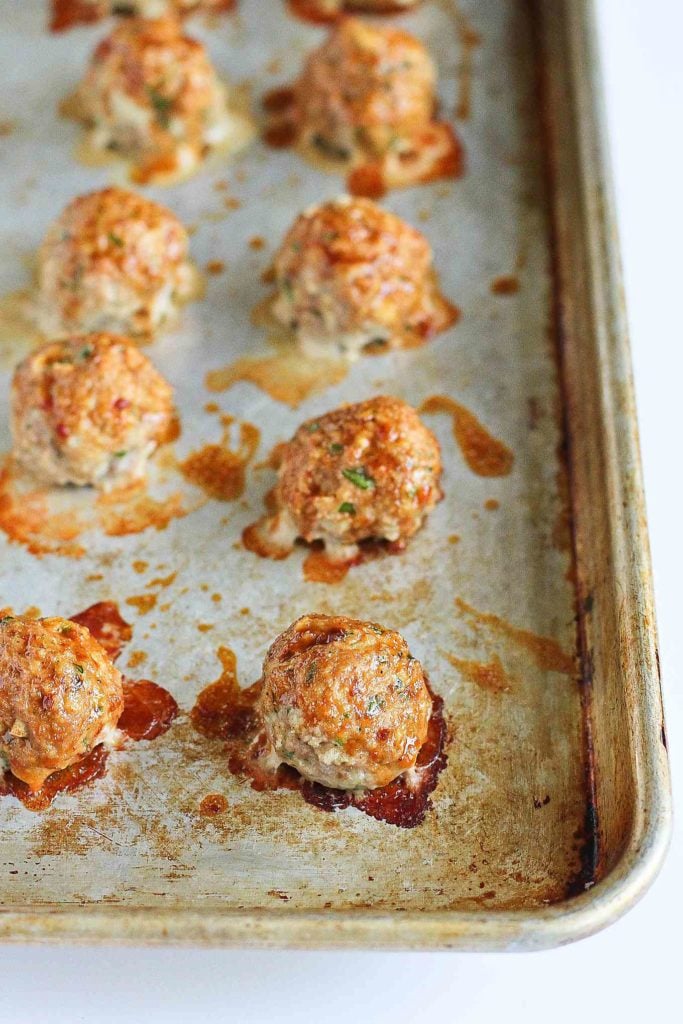 Turkey meatballs on a baking sheet, brushed with a hoisin based sauce.