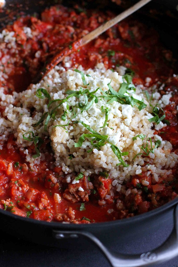 Tomato sauce with ground turkey and brown rice in a large skillet.