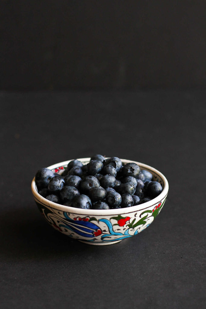 Fresh blueberries in a patterned bowl.