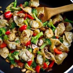 Wonton stir fry with broccoli, mushrooms and bell pepper in a nonstick skillet.