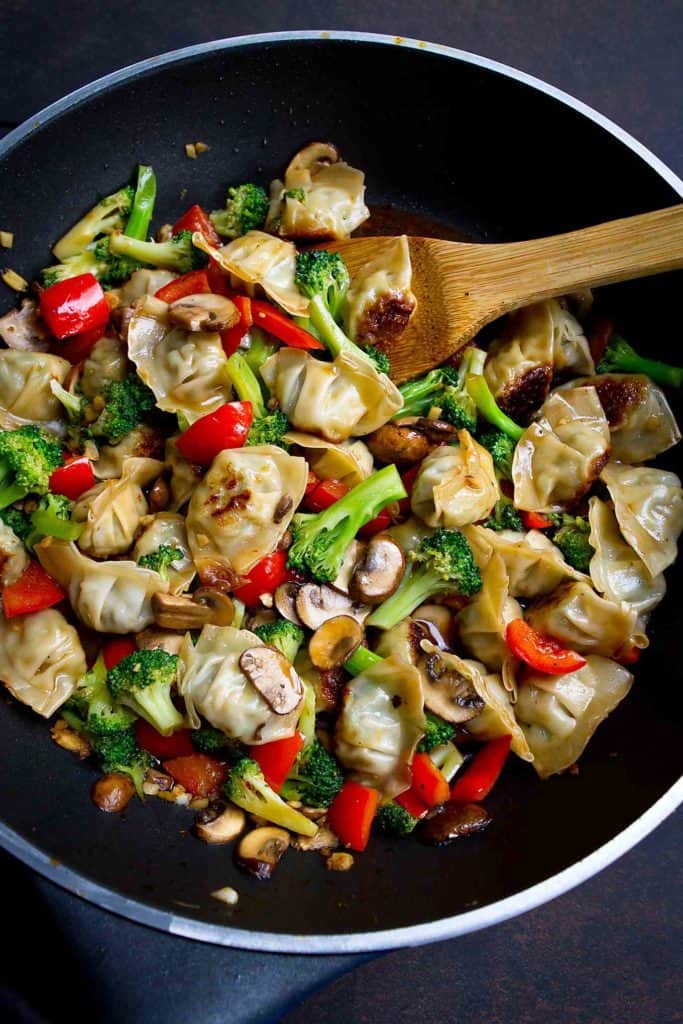Wonton stir fry with broccoli, mushrooms and bell pepper in a nonstick skillet.