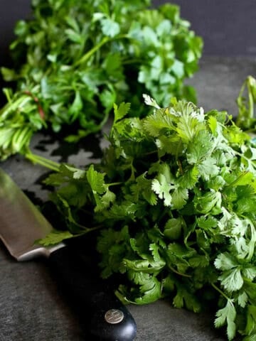 Learn how to chop parsley and cilantro properly so you can prepare them in seconds when prepping your next meal. No need to pull the leaves off of the stems! #parsley #howto #cooking