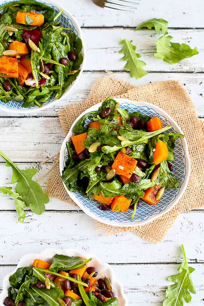 Treat yourself to this colorful, healthy and vegan roasted butternut squash salad. The sriracha lime dressing adds a great kick! 219 calories and 2 Weight Watchers SP | Warm | Arugula | Vegan | Vegetarian | Black Beans | Healthy #butternutsquash #squashrecipes #meatlessmonday #vegetarianrecipes #dinnerrecipes