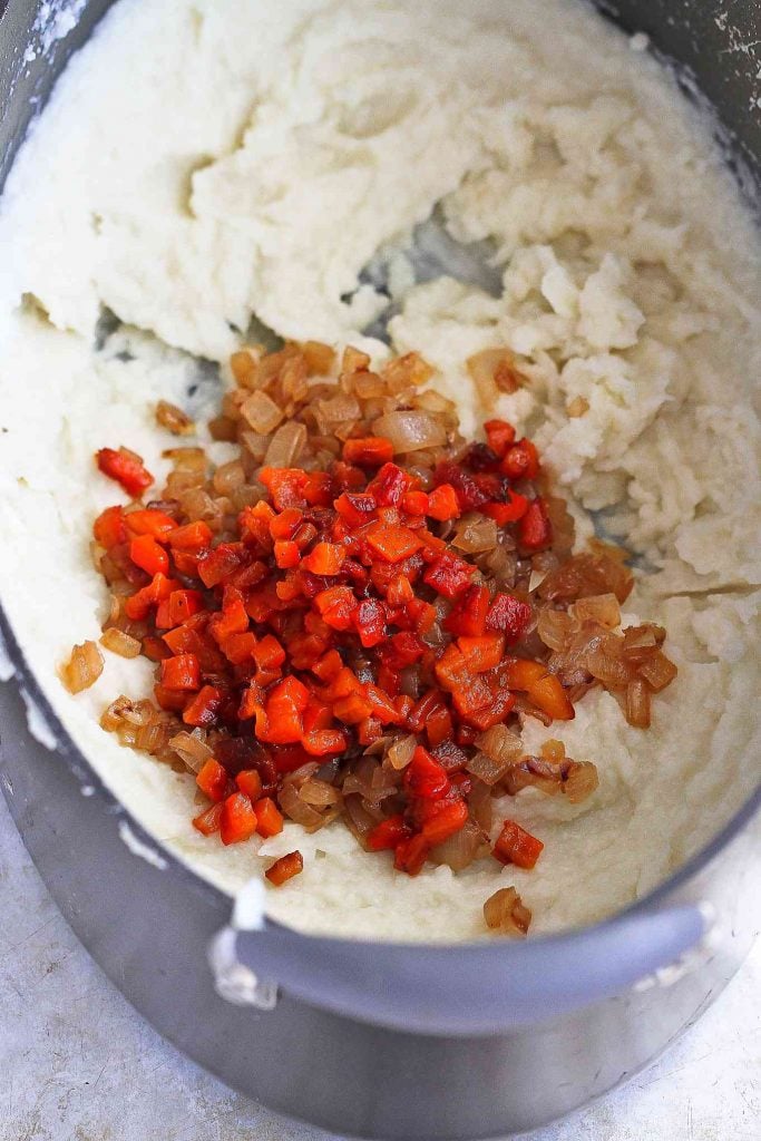 Caramelized onions and roasted peppers in a large saucepan with mashed potatoes