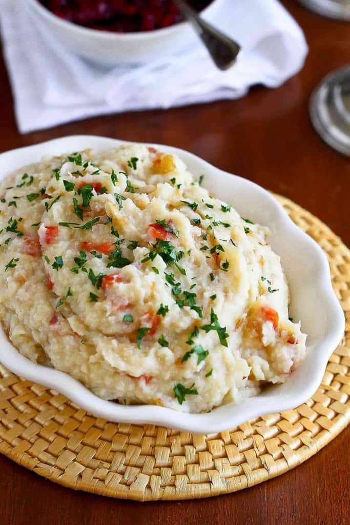 These dairy free and Vegan Mashed Potatoes and Cauliflower are studded with savory roasted peppers and caramelized onions. Perfect for holidays and special occasions! 112 calories and 3 Weight Watchers SP | Stovetop | No Butter | Recipe | Thanksgiving | Holidays | Cream Cheese | No Oil #veganpotatoes #mashedpotatoes #vegansidedishes #dairyfree #withoutbutter #Thanksgivingsides
