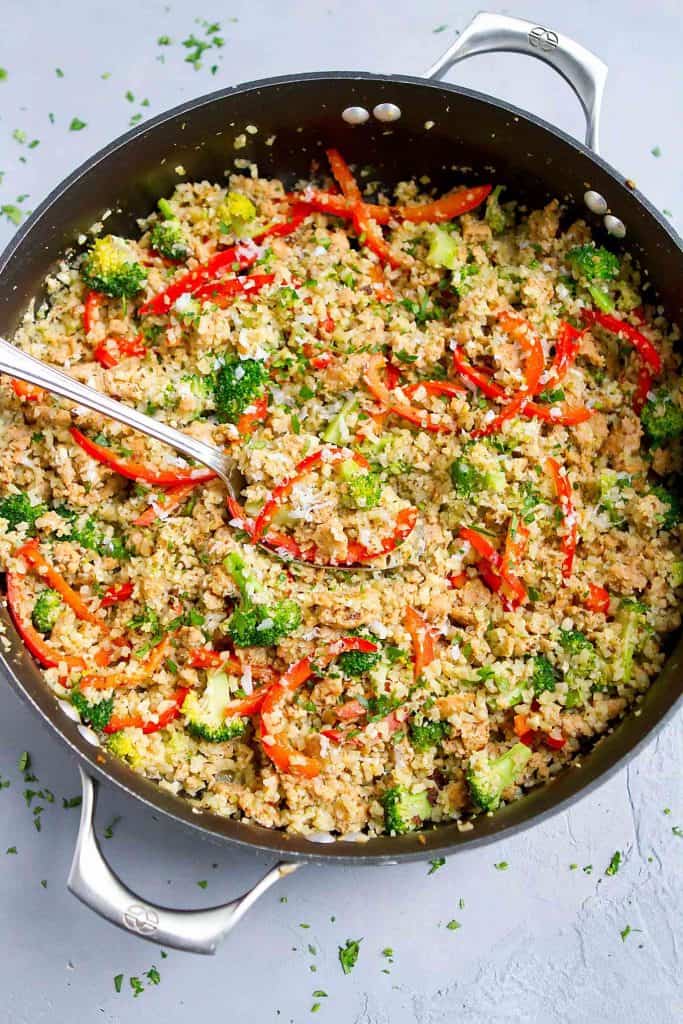 Serve up this One Pot Pesto Sausage Cauliflower Rice Meal on a busy weeknight. Packed with veggies & a breeze to make! 184 calories and 7 Weight Watchers SP | Skillet | Low Carb | Vegetable | Gluten Free | Recipe | Chicken | Healthy #cauliflowerrice #onepotmeal #onepotrecipe #healthyrecipes #easyrecipes