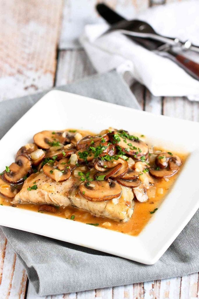 Baked halibut is a great way to work omega-3s into your diet. This one is topped with a delicious lightened-up Marsala sauce. 315 calories and 4 Weight Watchers SP | Oven | Healthy | Easy | Recipes | Italian #bakedfish #bakedhalibut #halibutrecipes #wwrecipes #smartpoints