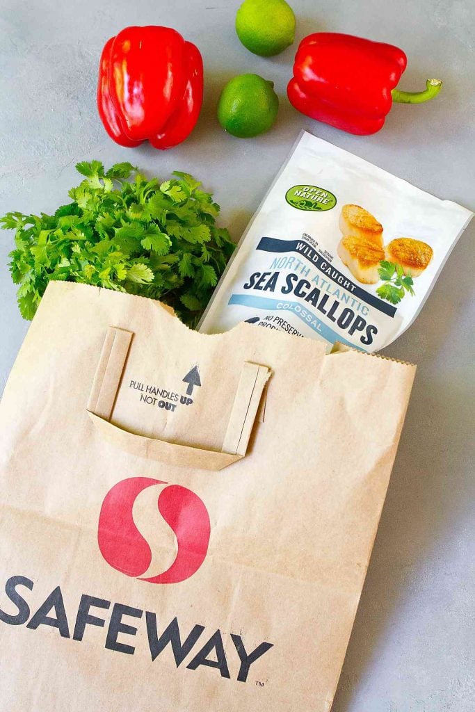 Safeway bag with bag of scallops, cilantro, bell peppers.