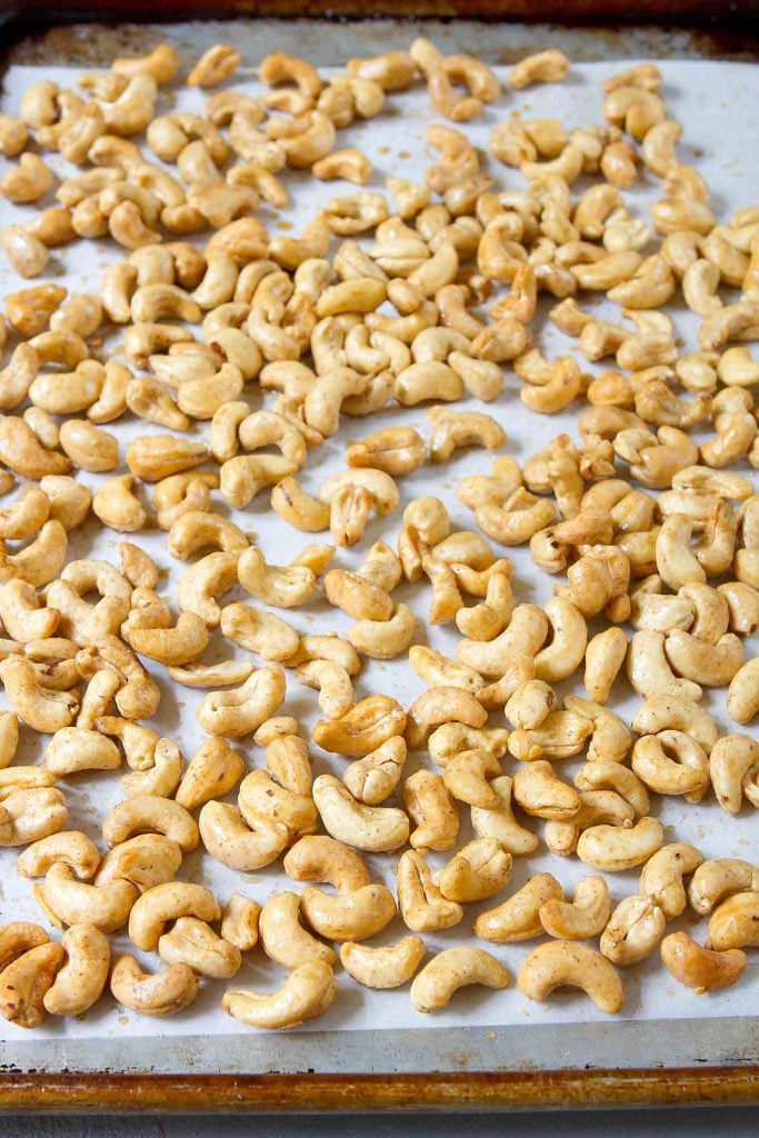 Maple cinnamon roasted cashews on a baking sheet lined with parchment paper.