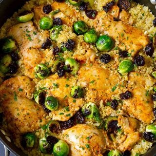 Cooked chicken thighs, quinoa and Brussels sprouts in a large nonstick skillet.