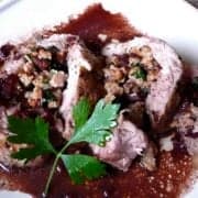 Stuffed pork tenderloin on a bed of red wine sauce.