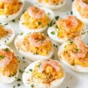 Deviled eggs with shrimp on top, sprinkled with parsley and paprika