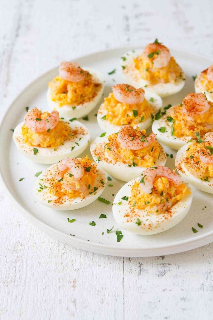 Several healthy shrimp deviled eggs arranged on a white plate.