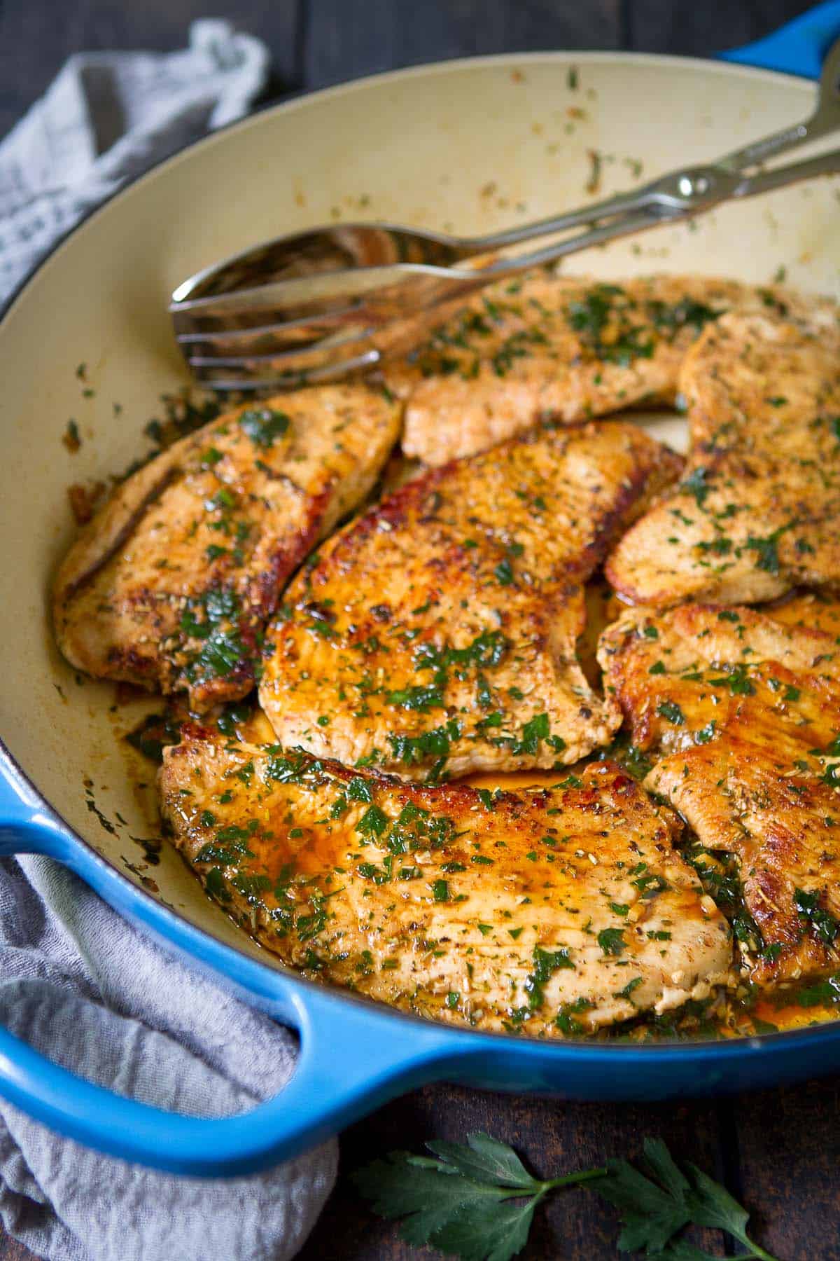 Cooked poultry fillets with wine sauce in a large skillet.