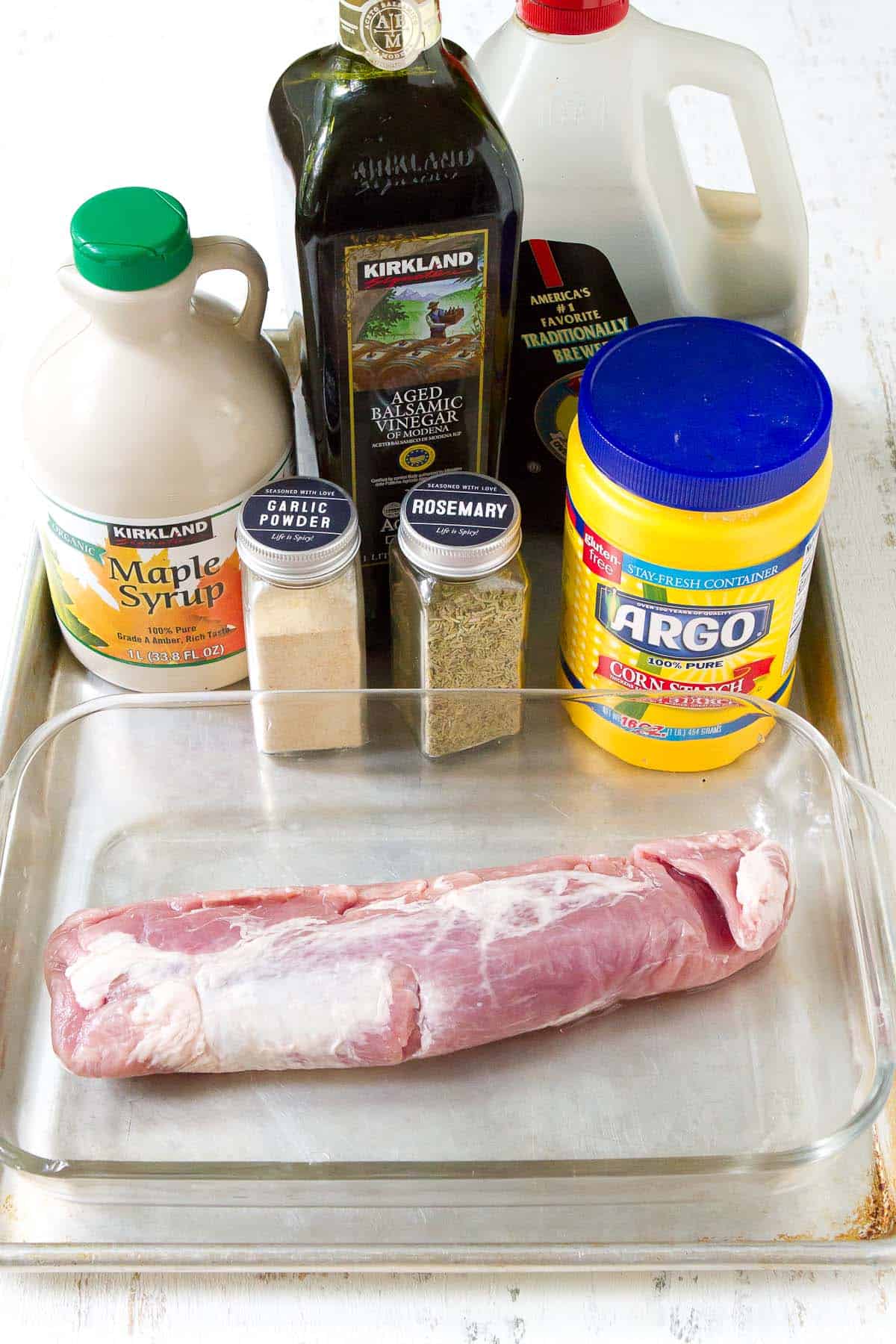 Ingredients for roasted pork tenderloin recipe on a baking sheet.