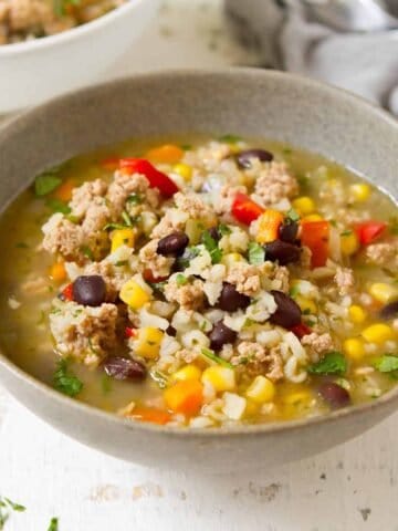 Ground turkey soup with black beans in a gray bowl.